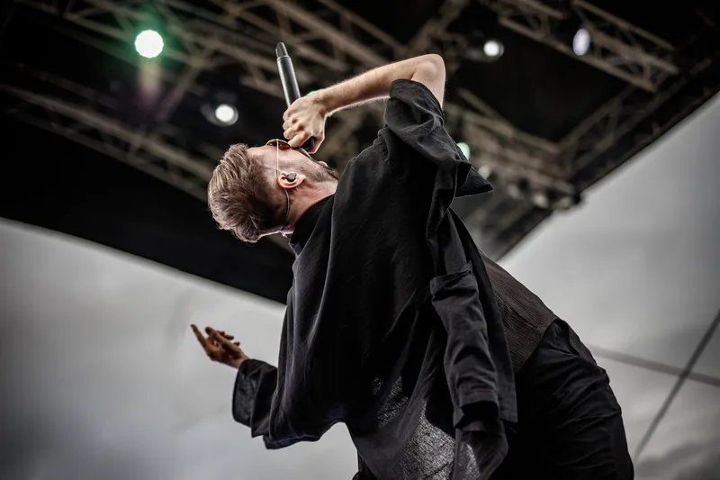 concert-Revnoir-Mozhell-chanteur-pose-cri-ciel-nuages