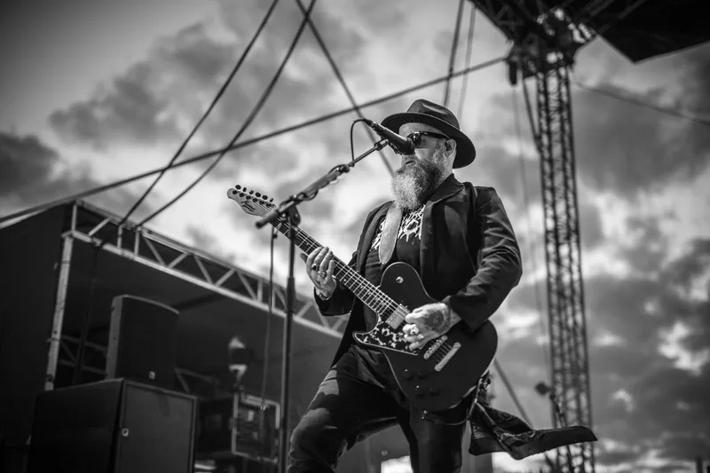 concert-Skindred-Mozhell-guitariste-ciel-nuages-noir-blanc