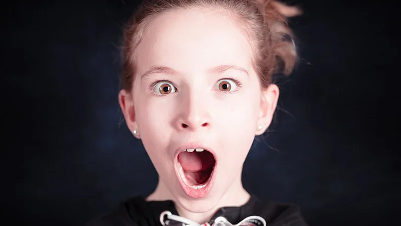 Portrait en couleurs d'un enfant affichant une expression de surprise et d'étonnement