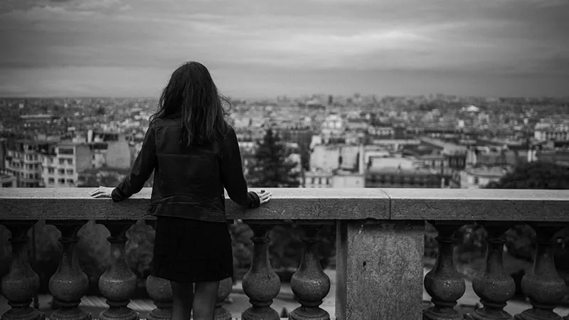 Silhouette de dos d'une femme face au paysage urbain de Paris depuis Montmartre